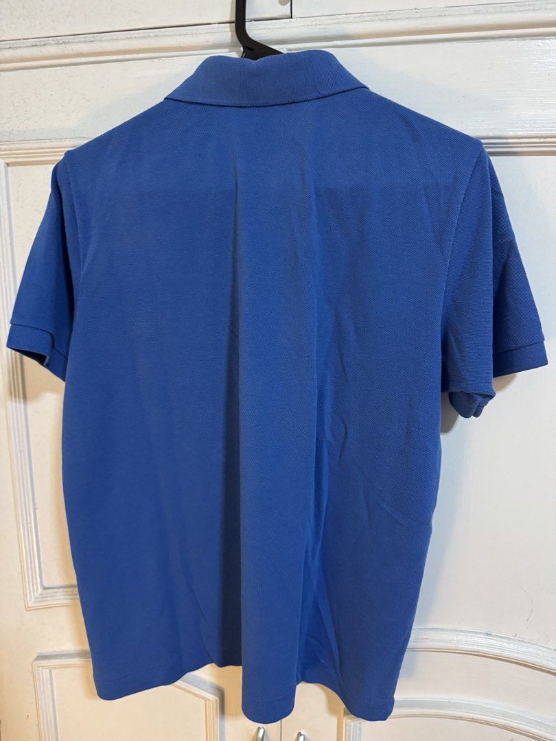 Lacoste Blue Polo Shirt Size 3 (Category: Tshirts & Polo Shirts ) located in Makati City. Submitted by mackyquintos (Listing ID 1466591949, Image 3). Description: - Brand: Lacoste - Color: Blue - Size: 3 (Classic Fit) - Design: Two-button placket, ribbed collar and cuffs - Logo: Iconic embroidered green crocodile on left chest - Condition: Clean fabric, no noticeable flaws - Style: Casual short sleeve.