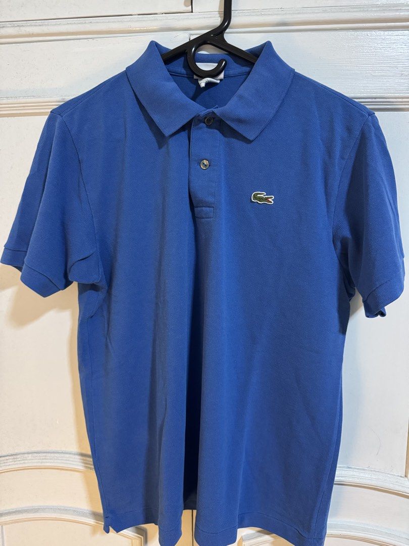 Lacoste Blue Polo Shirt Size 3 (Category: Tshirts & Polo Shirts ) located in Makati City. Submitted by mackyquintos (Listing ID 1466591949, Image 1). Description: - Brand: Lacoste - Color: Blue - Size: 3 (Classic Fit) - Design: Two-button placket, ribbed collar and cuffs - Logo: Iconic embroidered green crocodile on left chest - Condition: Clean fabric, no noticeable flaws - Style: Casual short sleeve.