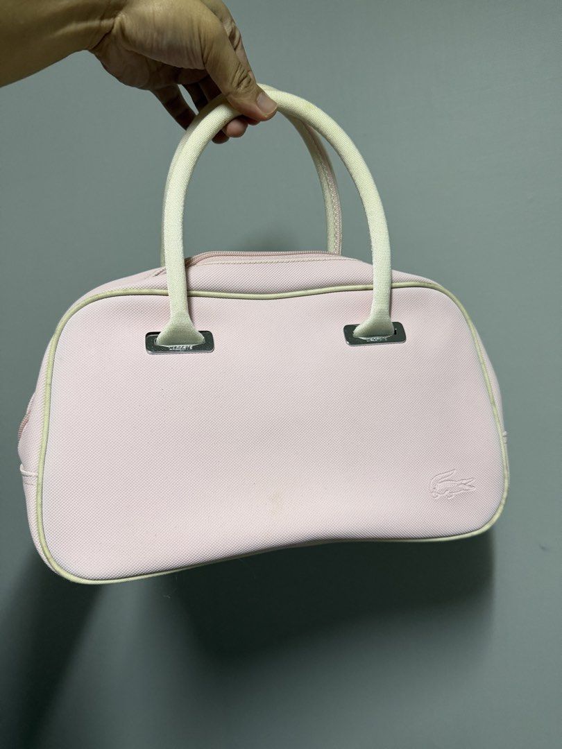 Lacoste Pink Handbag (Category: Luxury Bags & Wallets) located in Baguio. Submitted by truevintagelux_ph (Listing ID 1466731216, Image 1). Description: - Authentic pink Lacoste handbag with stylish white handles and piping trim - Features a subtle debossed crocodile logo on the lower right corner - Dual metal zipper closure with Lacoste-engraved pull tabs - Made of durable, structured canvas-like material with a flat, clean bottom base - Spacious