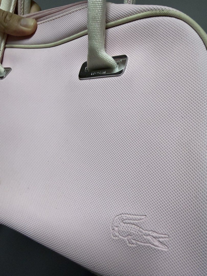 Lacoste Pink Handbag (Category: Luxury Bags & Wallets) located in Baguio. Submitted by truevintagelux_ph (Listing ID 1466731216, Image 3). Description: - Authentic pink Lacoste handbag with stylish white handles and piping trim - Features a subtle debossed crocodile logo on the lower right corner - Dual metal zipper closure with Lacoste-engraved pull tabs - Made of durable, structured canvas-like material with a flat, clean bottom base - Spacious