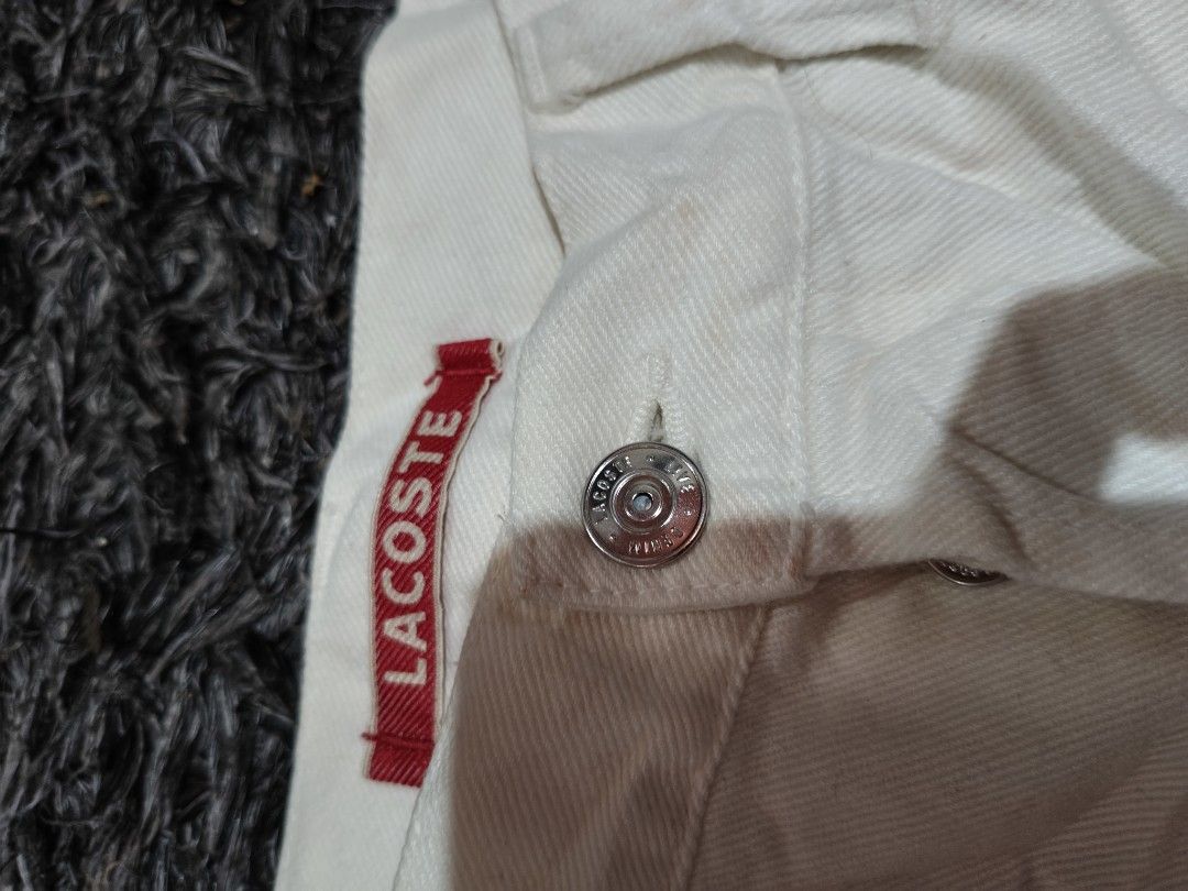 Lacoste White Denim Shorts (Category: Shorts) located in Laguindingan. Submitted by jingsuu22 (Listing ID 1466597318, Image 3). Description: - Brand: Lacoste - Color: White - Material: Denim - Closure: Button-fly with branded metallic buttons - Details: Small embroidered crocodile logo near the front pocket - Branding: Red LACOSTE brand label on the waistband - Fit/Style: Classic, versatile piece ideal for warmer weather.