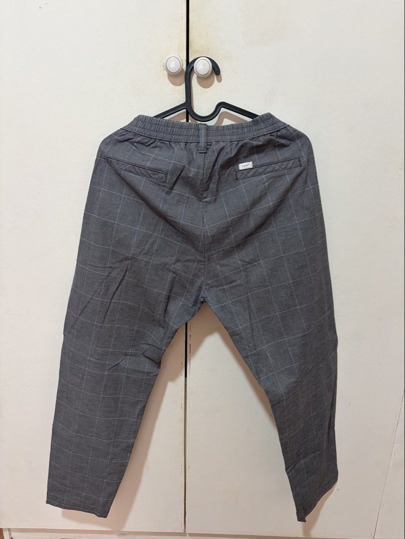 Lee Gray Checked Pants with Elastic Waist (Category: Other Bottoms) located in Dasmarinas. Submitted by luvaide (Listing ID 1466597718, Image 2). Description: - Brand: Lee - Color/Pattern: Grey with a subtle plaid/grid pattern - Waistband: Elastic at the back for a comfortable fit - Pockets: Two back welt pockets with a small branded patch on the right - Hem: Clean finish - Style: Ideal for casual or smart-casual outfits - Size: Can fit size 32.