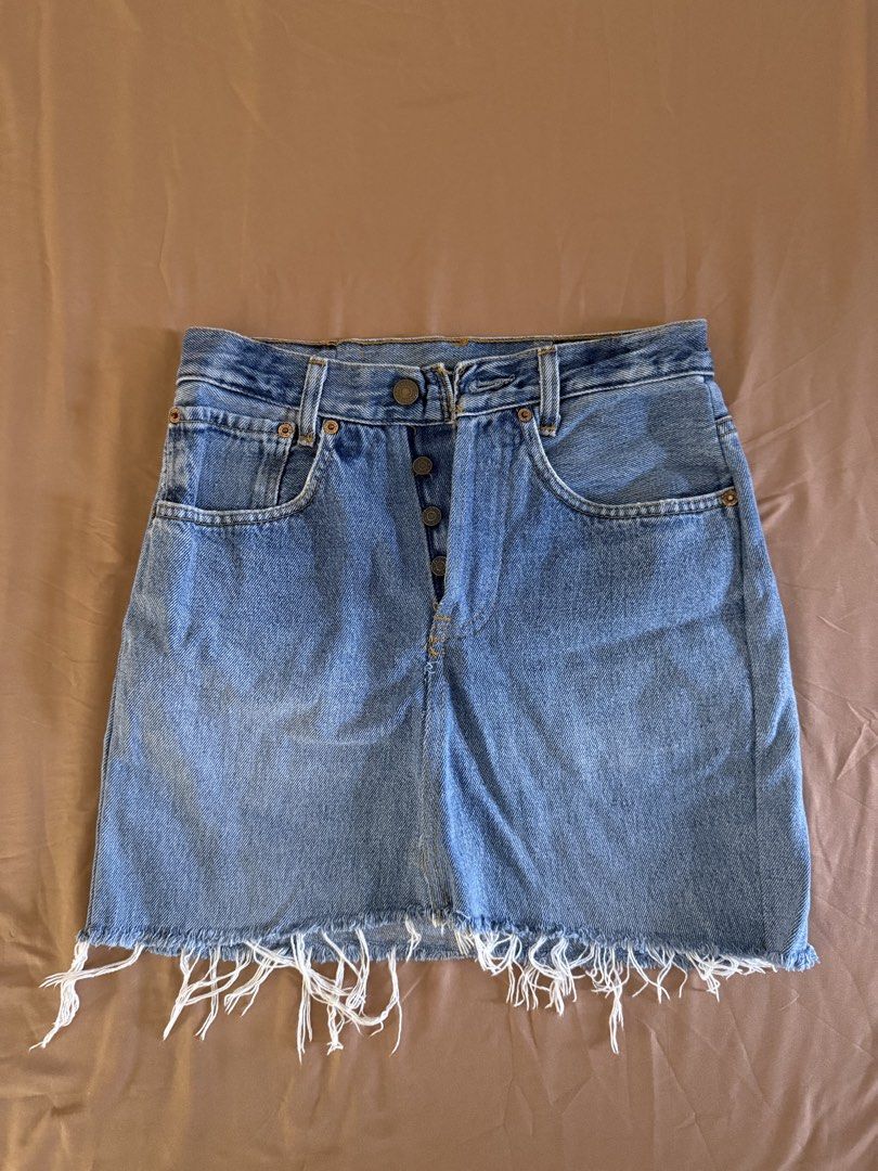 Levi's Denim Skirt (Category: Skirts) located in Pasay City. Submitted by cheyennesayson (Listing ID 1466573130, Image 1). Description: - Brand: Levi's - Wash: Medium blue denim - Fit: High-waisted with button fly - Details: Five-pocket styling, signature back pocket stitching, and raw frayed fringe hem - Condition: Great vintage look with minor wear near the back pocket seam (check photos) - Styling: Perfect for pairing with your favorite tees o