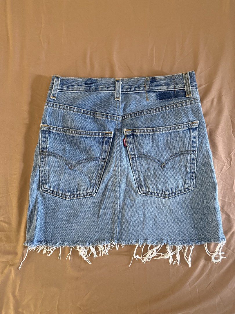 Levi's Denim Skirt (Category: Skirts) located in Pasay City. Submitted by cheyennesayson (Listing ID 1466573130, Image 3). Description: - Brand: Levi's - Wash: Medium blue denim - Fit: High-waisted with button fly - Details: Five-pocket styling, signature back pocket stitching, and raw frayed fringe hem - Condition: Great vintage look with minor wear near the back pocket seam (check photos) - Styling: Perfect for pairing with your favorite tees o