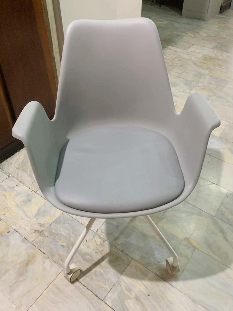 Light Grey Office Chair with Armrests and Wheels (Category: Office Furniture & Fixtures) located in Marikina City. Submitted by lovegoeson (Listing ID 1466642156, Image 3). Description: - Modern minimalist light grey shell chair - Built-in armrests and soft cushioned seat pad for all-day comfort - Sturdy white metal legs with smooth-rolling caster wheels - Ideal for home offices or study spaces - Clean build with minor signs of handling.