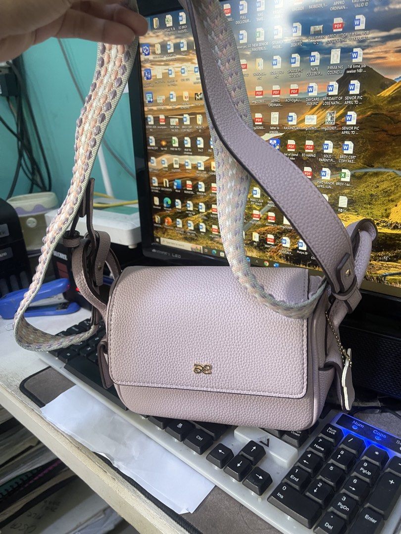 Lilac Leather Crossbody Bag with Patterned Strap (Category: Cross-body Bags) located in Manila. Submitted by esmhieraiks (Listing ID 1466624856, Image 2). Description: - holb little bunny Material: Premium lilac pebbled leather - Closure: Front flap with secure metal logo clasp - Strap: Wide, stylish pastel patterned strap (pink, white, purple) - Extras: Matching side leather charm included - Protection: Gold-tone metal feet on the bottom base - 