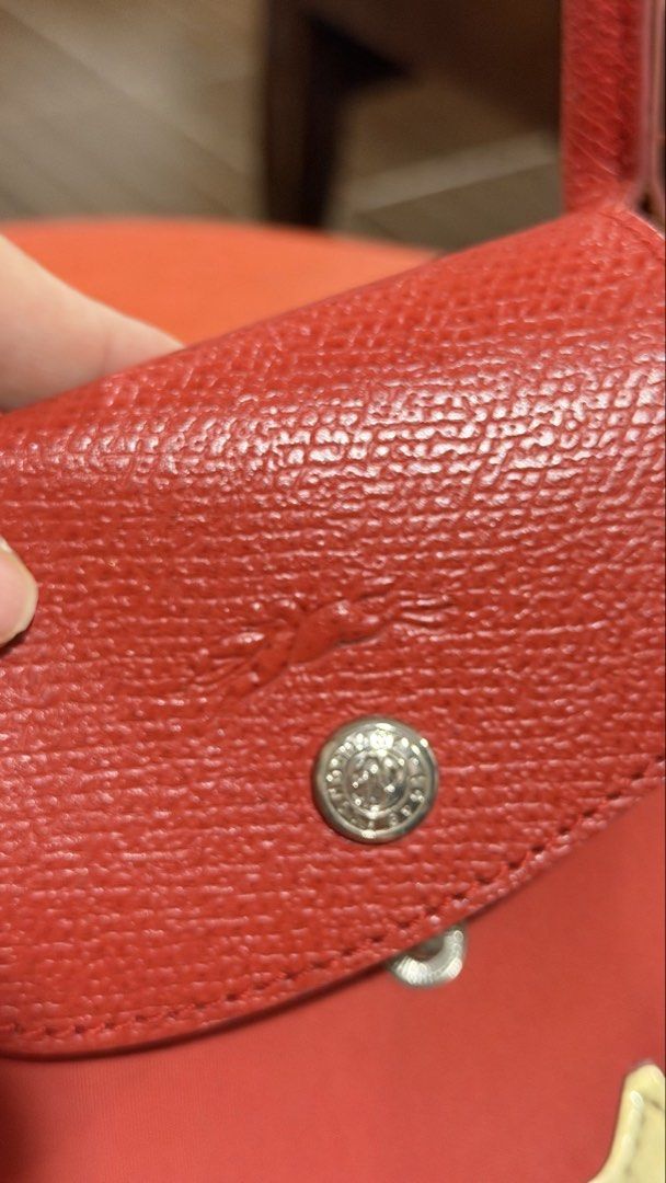 Longchamp Le Pliage Red Tote Bag with Strap (Category: Luxury Bags & Wallets) located in San Fernando. Submitted by jusaki17 (Listing ID 1466703053, Image 3). Description: - Brand: Longchamp - Color: Red with leather trim and gold-tone hardware - Material: Durable nylon - Features: Top handles, detachable shoulder strap, zip-top closure with snap flap, and iconic gold horse appliqué - Interior: Roomy main compartment with matching printed fabric 