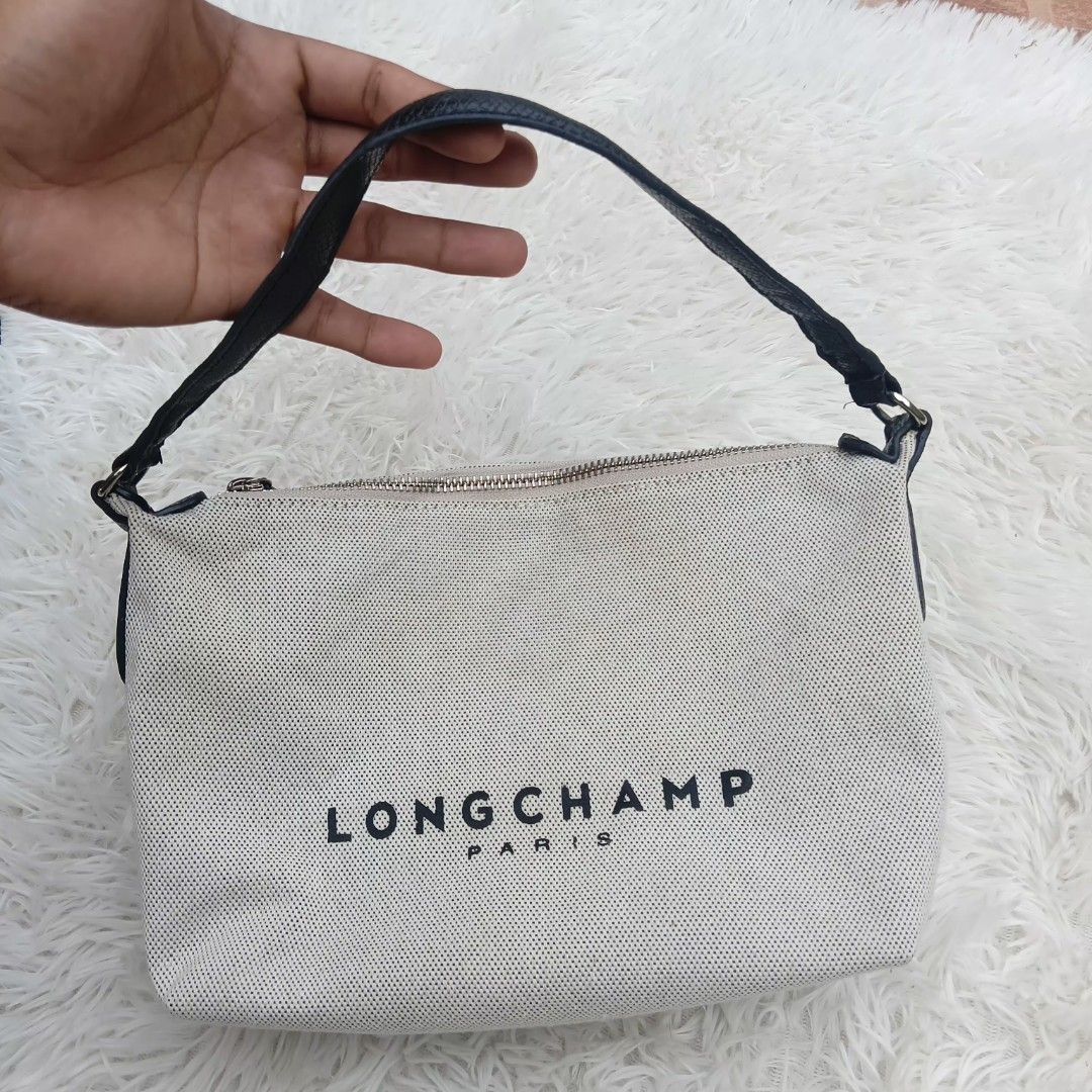 Longchamp Paris Canvas Handbag (Category: Luxury Bags & Wallets) located in Gattaran. Submitted by thrift_wiseph (Listing ID 1466678920, Image 2). Description: - Brand: Longchamp Paris - Color: Off-white canvas with striking black branding and black leather handle - Closure: Secure top zipper closure - Interior: Brown fabric lining with an extra zippered pocket for organization - Authenticity: Features interior leather tag reading 'Longchamp 1948