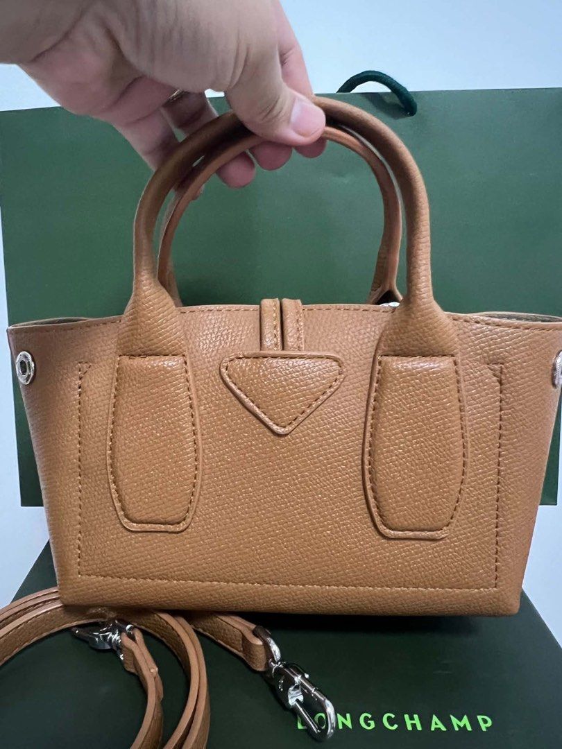 Longchamp Roseau Top Handle Bag (Category: Luxury Bags & Wallets) located in Abulug. Submitted by jamiecammie (Listing ID 1466701205, Image 2). Description: - Authentic Tan Leather Longchamp Roseau Bag - Structured design with signature silver-tone bamboo toggle closure - Includes matching detachable shoulder strap and top handles - Interior features zippered pocket with racing horse logo plaque - Comes complete with original green box and paper 