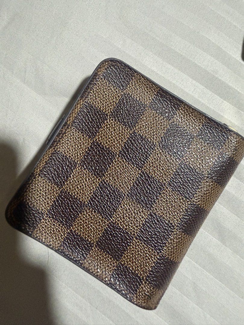 Louis Vuitton Damier Ebene Compact Wallet (Category: Luxury Bags & Wallets) located in Davao. Submitted by ketfong (Listing ID 1466591629, Image 2). Description: Louis Vuitton wallet in Damier Ebene canvas with brown leather snap closure tab. Classic checkered brown pattern on exterior. Interior includes multiple card slots and a side zip pocket for coins. Compact fold design, fits easily into bags or pockets. Gold-tone hardware zipper pull with 