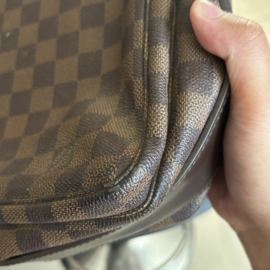 Louis Vuitton Damier Ebene Messenger Bag (Category: Luxury Bags & Wallets) located in Bambang. Submitted by heats777 (Listing ID 1466664119, Image 2). Description: - Classic brown checked messenger bag with dark brown strap and trim - Secure front flap closure and dual metal zipper pulls stamped with LV logo - Features engraved metallic snap button detail - Adjustable canvas shoulder strap for comfortable daily carry - Condition: Shows minor wear