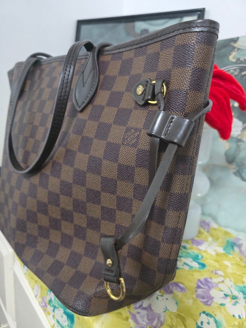 Louis Vuitton Damier Ebene Neverfull Tote Bag (Category: Luxury Bags & Wallets) located in Binan City. Submitted by geraldinef58404 (Listing ID 1466617874, Image 3). Description: Louis Vuitton Neverfull tote bag in the classic Damier Ebene canvas print. Brown and dark brown checkered pattern with dark brown leather shoulder straps and side cinch laces. Gold-tone hardware throughout. Red interior lining inside. Roomy everyday shoulder bag with sli