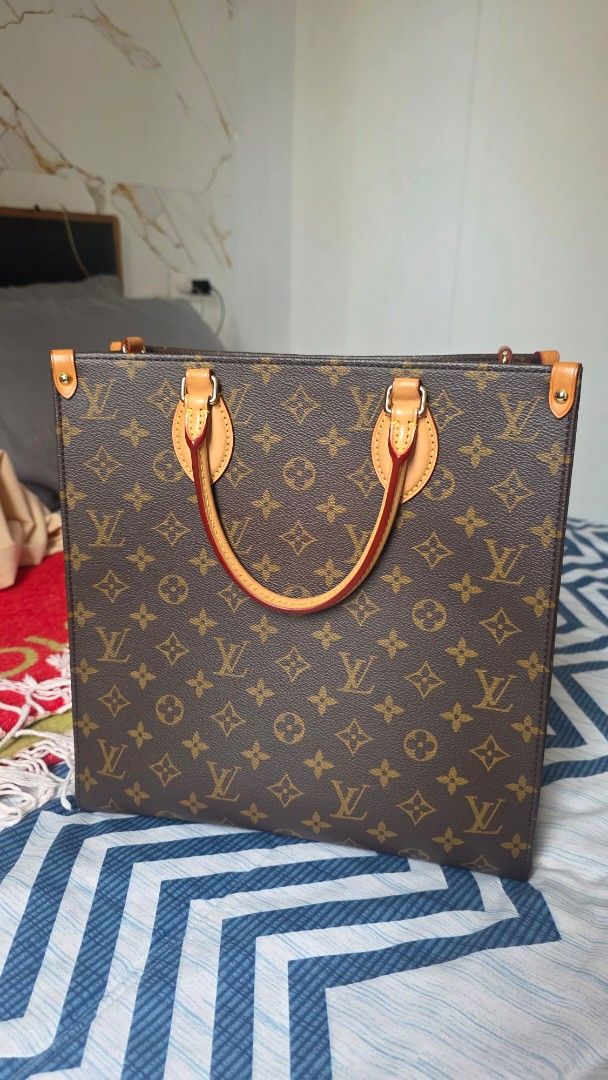 Louis Vuitton Sac Plat PM (Category: Luxury Bags & Wallets) located in Makati City. Submitted by jadulanju71818 (Listing ID 1466576117, Image 2). Description: - Authentic Louis Vuitton monogram tote bag in classic brown - Vibrant red fabric interior with multiple compartments and a secure zip pocket - Classic structured shape with premium gold-tone hardware - Comfortable vachetta leather top handles - Includes matching monogram shoulder strap for