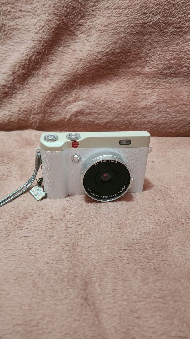 LUXARA Digital Camera (Category: Cameras) located in Bulacan. Submitted by rynnhoon (Listing ID 1466567596, Image 2). Description: - Model: LUXARA Compact Digital Camera (White) - Lens: Fixed 18.5mm wide-angle lens - Condition: Clean body with minimal signs of handling - Extras: Includes grey strap with small camera charm - Functionality: Battery and memory card slots fully functional, ready to shoot straight away - Use Case: Great everyday pocke