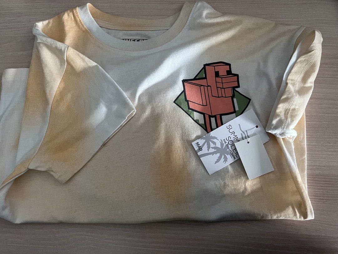 Mad Engine Minecraft T-Shirt Large (Category: Babies & Kids Fashion) located in Paranaque City. Submitted by PrelovedClosetetc (Listing ID 1466573581, Image 3). Description: - Brand new with original store tags - Official Mad Engine Minecraft merchandise - Unique yellow and white tie-dye wash effect - Cute chicken design on the front chest - Bold 'Survival Mode' graphic print on the back - Comfortable short sleeves with a classic crew neck - Mate