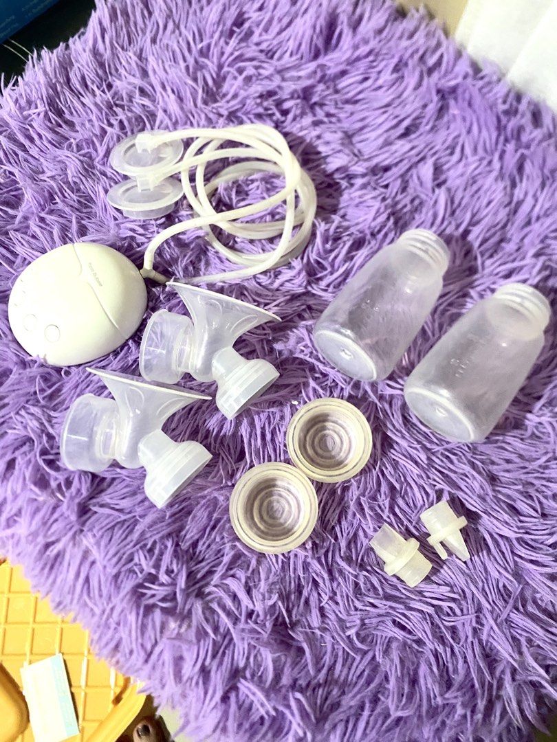 Manual Electric Breast Pump w/ Manual Pump (Category: Breastfeeding & Bottle Feeding) located in Quezon City. Submitted by macastillo1998 (Listing ID 1466591110, Image 3). Description: Real Bubee electric breast pump unit in white. Includes motor unit, tubing, two collection bottles, breast shields, duckbill valves, and silicone diaphragms. Compact dual pump setup for expressing milk at home or away. All parts clean and laid out clearly. Handy se