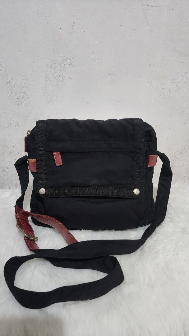 Maphisto Black Messenger Bag | PH Brand (Category: Cross-body Bags) located in Manila. Submitted by rionbenedicto (Listing ID 1466585730, Image 2). Description: - Material: Durable black nylon with dark red leather accents - Closure: Secure flap with dual snap buttons • With red accents • Practical everyday bag Condition: Preloved, good condition. - Storage: Handy exterior front pocket - Strap: Adjustable fabric shoulder strap - Perfect for: Scho