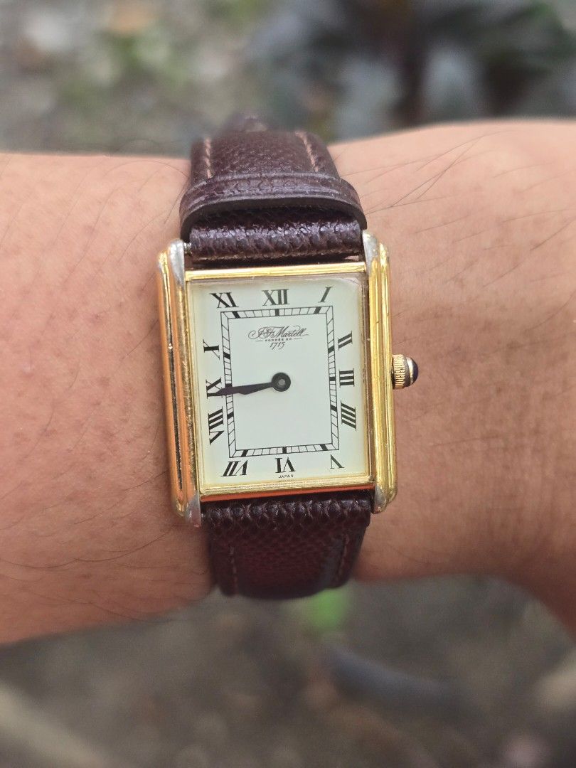 Martell Classic Watch Rectangular Tank Roman Numerals (Category: Luxury Watches) located in Manila. Submitted by timearcph (Listing ID 1466608645, Image 1). Description: - Brand/Model: Martell classic rectangular watch - Dial: White with black Roman numerals and slender black hands - Case: Gold-tone with a stylish blue cabochon crown (shows minor wear on edges) - Strap: Dark brown textured leather with contrast stitching (16mm width) - Movement: 