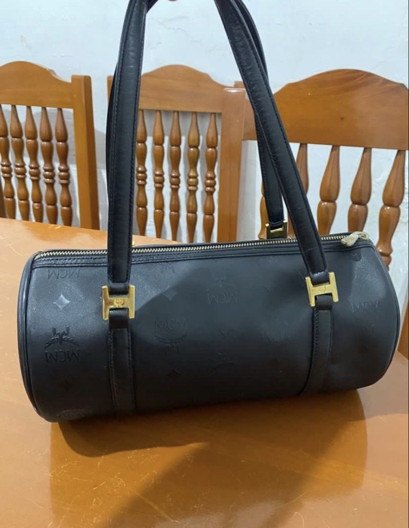 MCM Black Monogram Barrel Handbag (Category: Luxury Bags & Wallets) located in Naga. Submitted by cozydapper (Listing ID 1466628451, Image 2). Description: - Authentic MCM black barrel bag with iconic monogram print - Elegant gold-tone hardware featuring the München plaque and code P5885 - Comfortable dual shoulder straps with square gold loop attachments - Secure top-zip closure - Clean exterior and hardware overall.