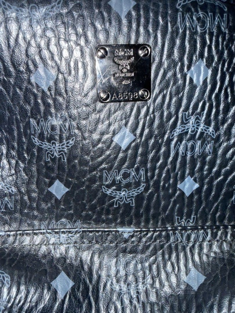 MCM Black Visetos Leather Backpack (Category: Luxury Bags & Wallets) located in Quezon City. Submitted by prelovedco (Listing ID 1466679359, Image 2). Description: - Brand: MCM - Color/Pattern: Black textured with iconic monogram print - Hardware: Silver-toned metal with München logo plate & serial number A8598 - Features: Zippered front pocket, sturdy top handle, and adjustable branded fabric shoulder straps - Condition: Shows some wear around t