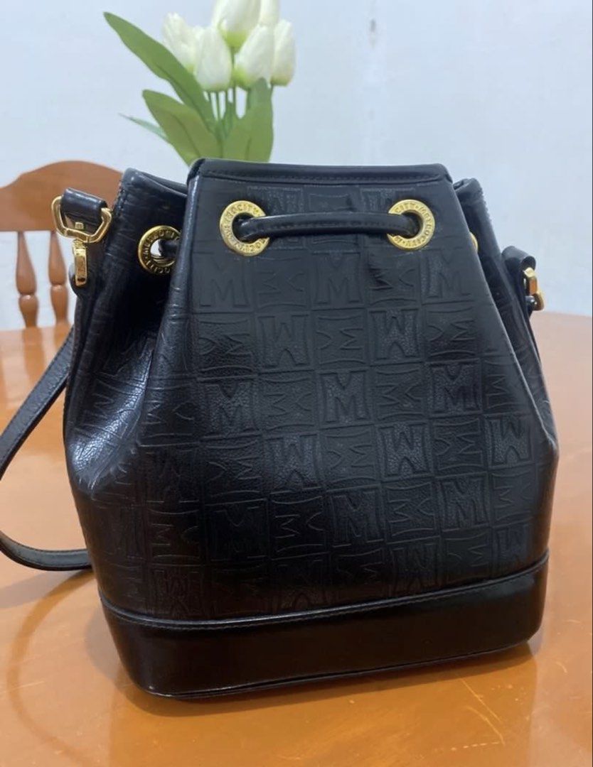 Metrocity Black Monogram Bucket Bag with Gold Hardware (Category: Luxury Bags & Wallets) located in Naga. Submitted by cozydapper (Listing ID 1466629428, Image 3). Description: - Brand: Metrocity - Color: Classic Black - Pattern: All-over embossed monogram - Closure: Secure drawstring with gold-tone metal eyelets - Details: Front logo emblem and gold hardware hooks - Strap: Adjustable long shoulder strap - Interior: Fabric lining with a zip pocke