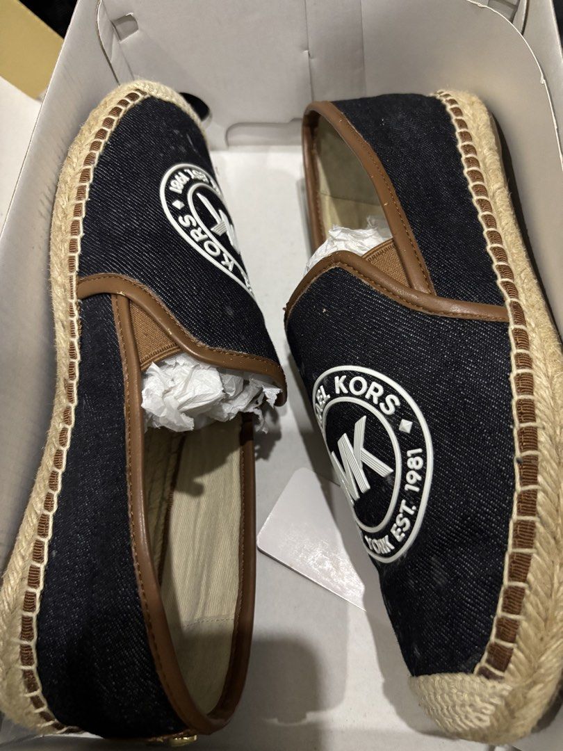 Michael Kors Hastings Espadrilles Denim Size 7M (Category: Flats & Sandals) located in Malabon City. Submitted by everythingpreloveddd (Listing ID 1466722917, Image 3). Description: - Brand: Michael Kors Hastings - Style: Slip-on espadrilles with jute-wrapped sole - Color/Design: Dark denim upper, brown trim, and large white MK logo patch - Size: US 7M - Condition: Never worn, brand new in box with original tissue paper.