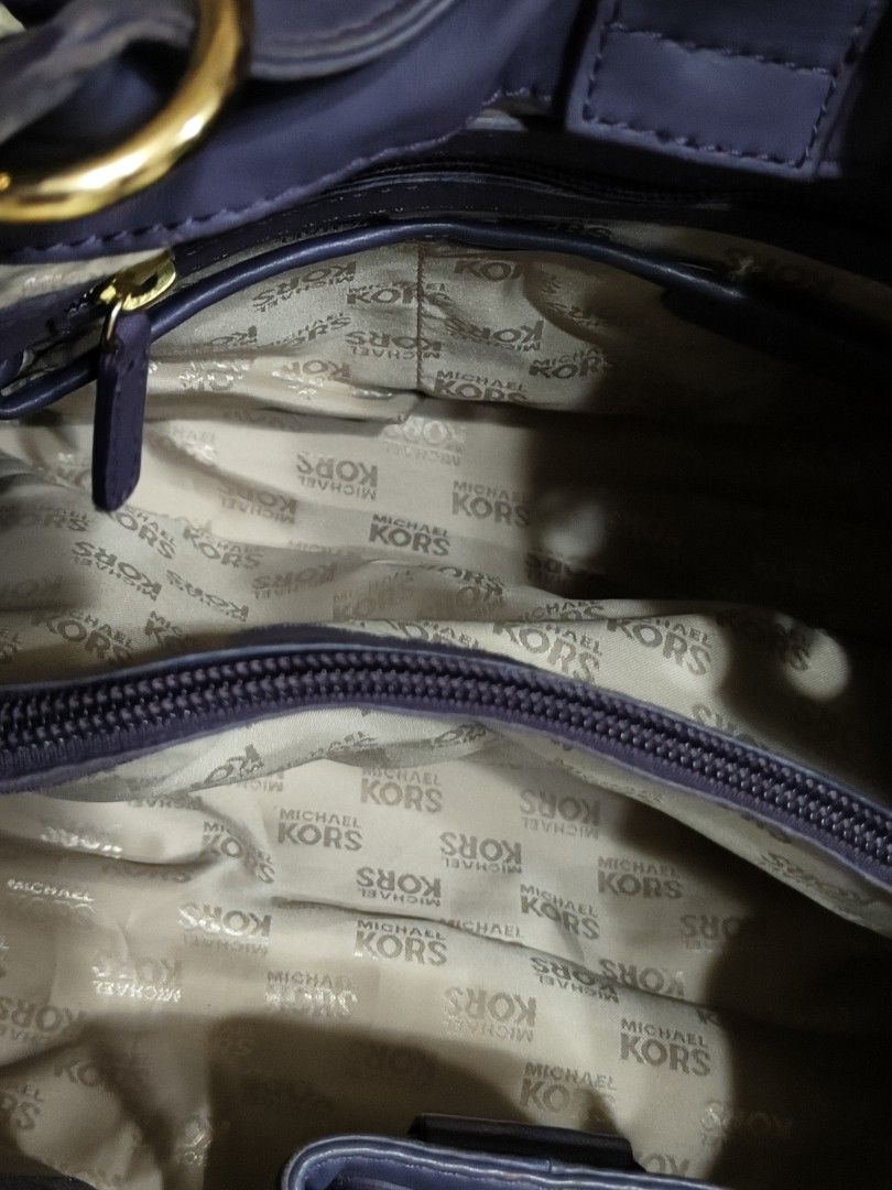 Michael Kors Purple Leather Shoulder Bag (Category: Luxury Bags & Wallets) located in Cavite. Submitted by sweetalittlemonstertoo (Listing ID 1466572908, Image 3). Description: - Brand: Michael Kors - Material: Smooth purple leather with gold hardware - Design: Structured yet slouchy shape with front drawstring detail and double shoulder straps - Interior: Clean beige monogram fabric lining with zippered and slip compartments - Authenticity/Origi