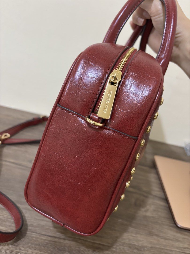 Michael Kors Thompson MD Duffle Satchel Cherry (Category: Luxury Bags & Wallets) located in Balayan. Submitted by authenticfindsbymrb (Listing ID 1466707070, Image 2). Description: - Brand: Michael Kors - Style: Thompson Medium Duffle Satchel - Color: Cherry Red - Hardware: Gold-tone with chic front stud details - Features: Dual top handles, detachable shoulder strap, zip-top closure, and hanging MK logo charm - Condition: Brand new with original