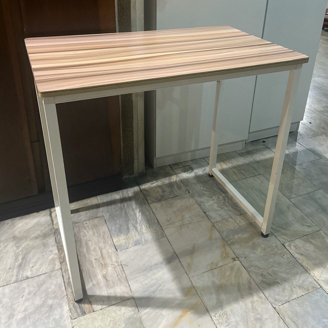 Minimalist study desk with wooden top and white frame (Category: Tables & Sets) located in Marikina City. Submitted by lovegoeson (Listing ID 1466569089, Image 1). Description: - Stylish wood grain top with clean white metal legs - Compact design, perfect for small rooms and tight corners - Sturdy steel frame ensures a wobble-free workspace - Smooth surface that is easy to wipe clean.