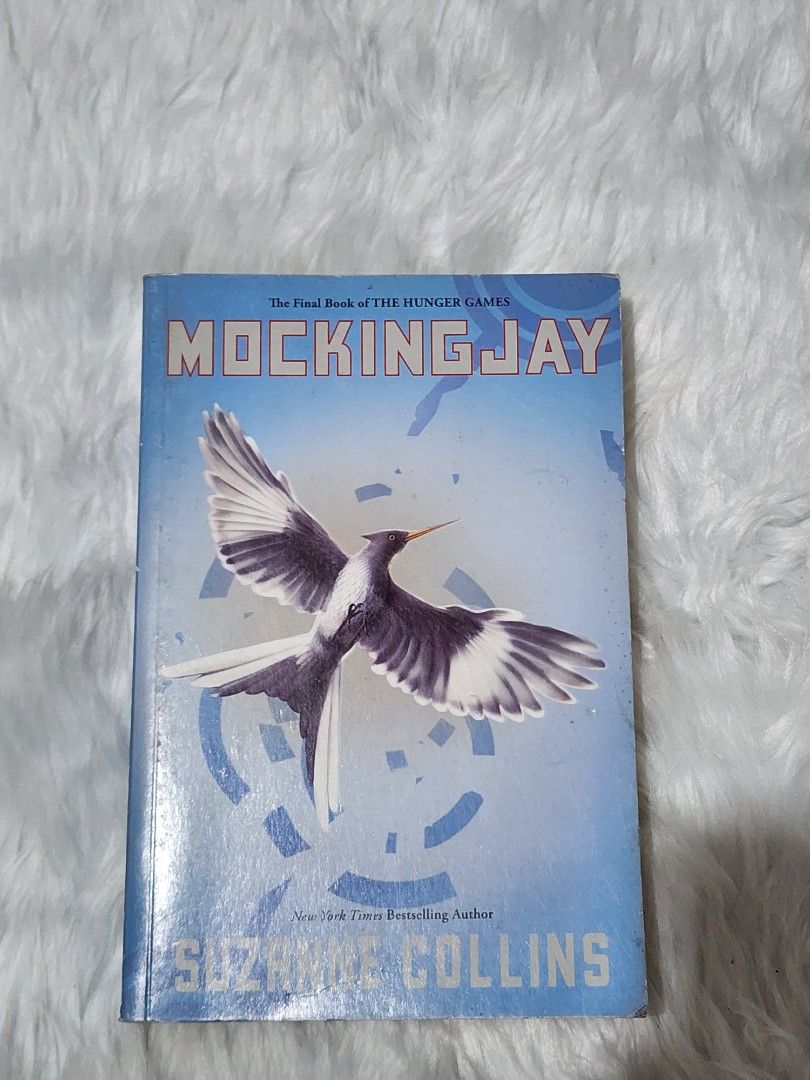 Mockingjay by Suzanne Collins The Hunger Games Book (Category: Storybooks) located in Manila. Submitted by rionbenedicto (Listing ID 1466588257, Image 1). Description: - Title: Mockingjay by Suzanne Collins - Format: Paperback with classic blue mockingjay cover - Condition: Great read, pages intact and ready for a new owner - Perfect for: Completing your Hunger Games book collection.