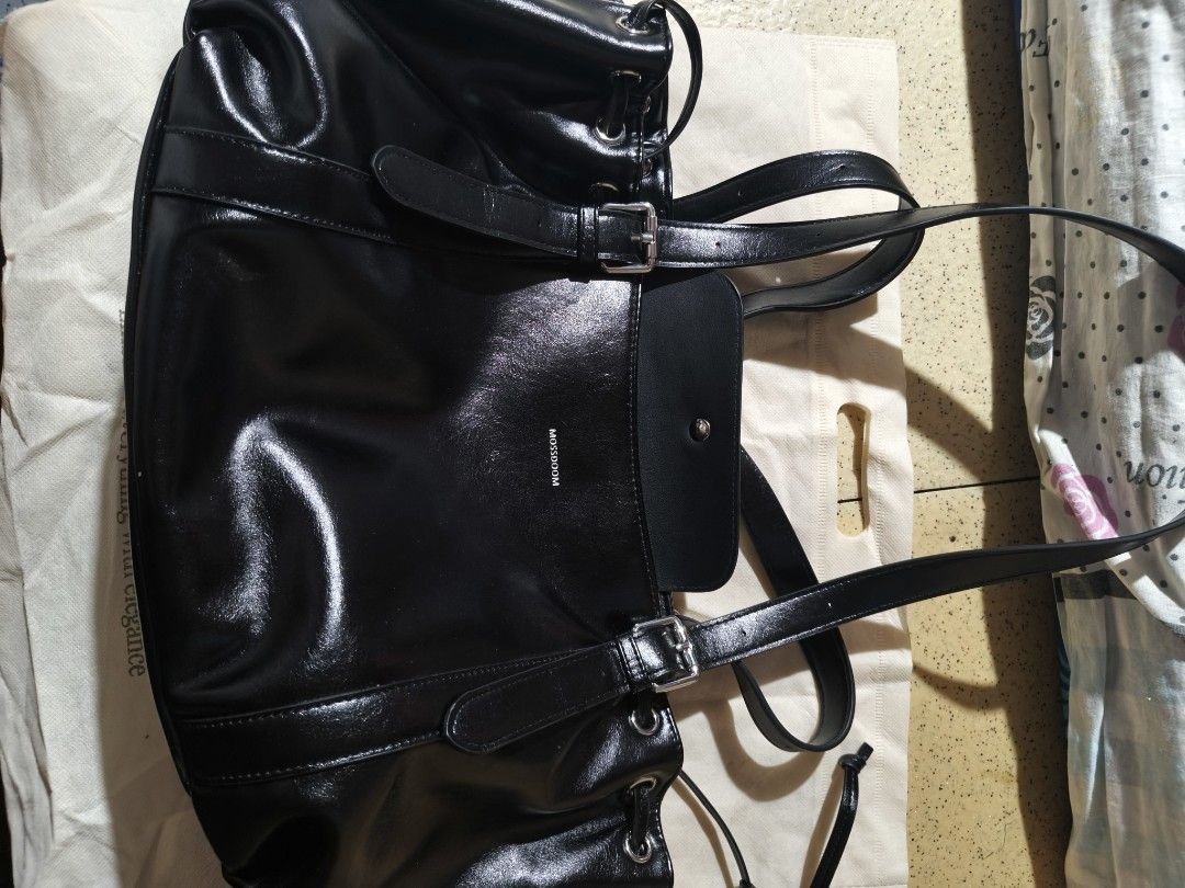 MOSSDOOM Black Shoulder Bag Tote (Category: Shoulder Bags) located in Pasig City. Submitted by happy.alexandraicydeguzman (Listing ID 1466739769, Image 1). Description: - Brand: MOSSDOOM - Color: Black with a glossy finish - Material: Premium faux leather - Hardware: Silver-tone with stylish buckle accents - Storage: Large main compartment with an inner zip pocket - Details: Trendy drawstring bungee cord sides - Capacity: Fits tablets up to 11 in