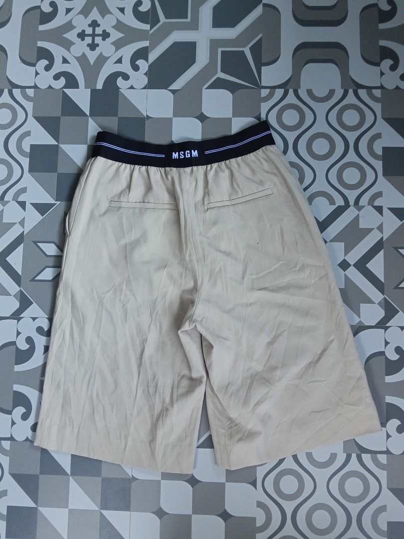 MSGM Beige Shorts with Branded Elastic Waistband (Category: Shorts) located in Lingayen. Submitted by rahzzelula73279 (Listing ID 1466713439, Image 2). Description: - Brand: MSGM - Color: Beige - Waistband: Elastic with iconic white and blue striped brand lettering - Pockets: Two back welt pockets - Style: Clean finish, ideal for casual wear - Condition: Great piece, highly versatile.