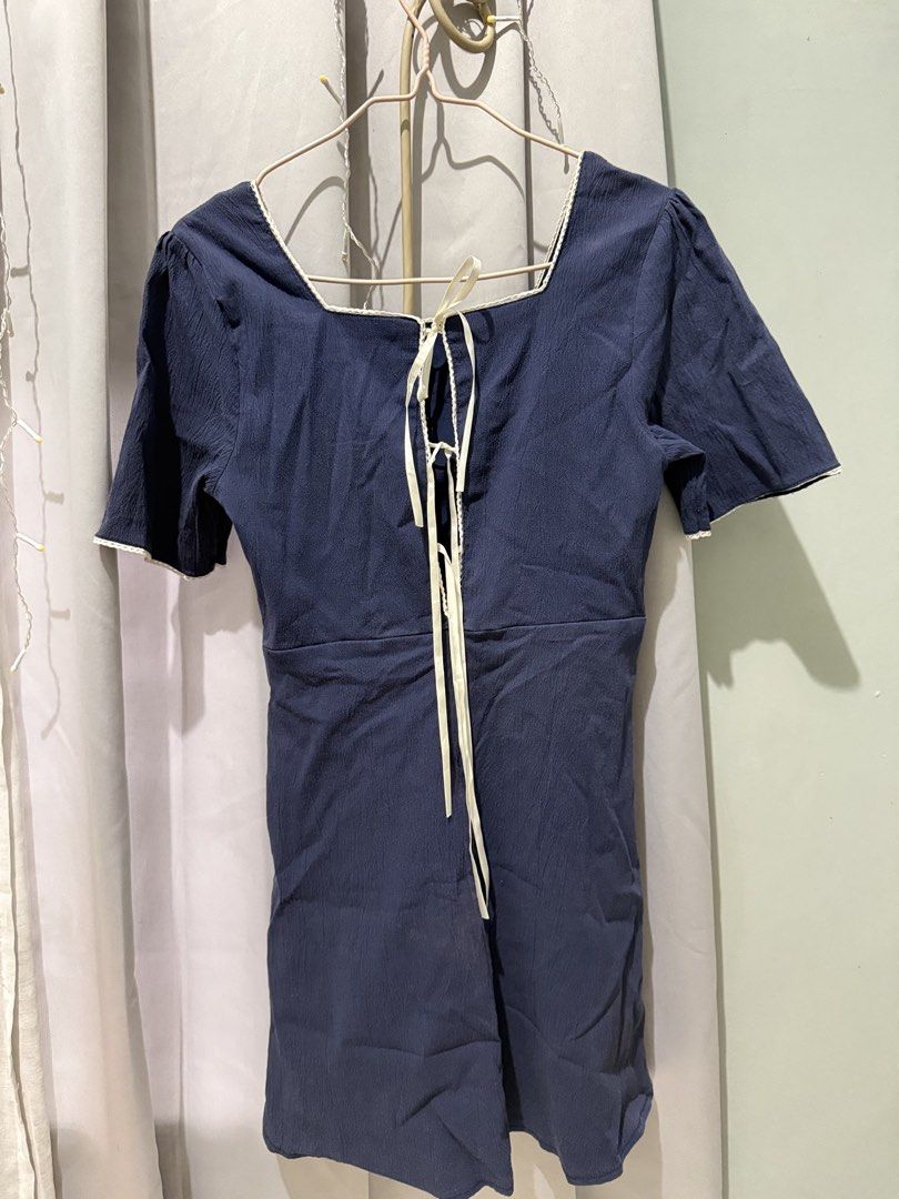 Navy Blue Square Neck Dress with Back Tie (Category: Dresses) located in Cagayan de Oro. Submitted by ninaaam (Listing ID 1466772727, Image 2). Description: - Color: Navy blue with white contrast piping - Design: Square neckline on front and back with long ribbon ties down the center - Sleeves: Short sleeves - Fit & Style: Lightweight textured fabric, waist seam, and slightly gathered skirt - Perfect for: Casual everyday wear.