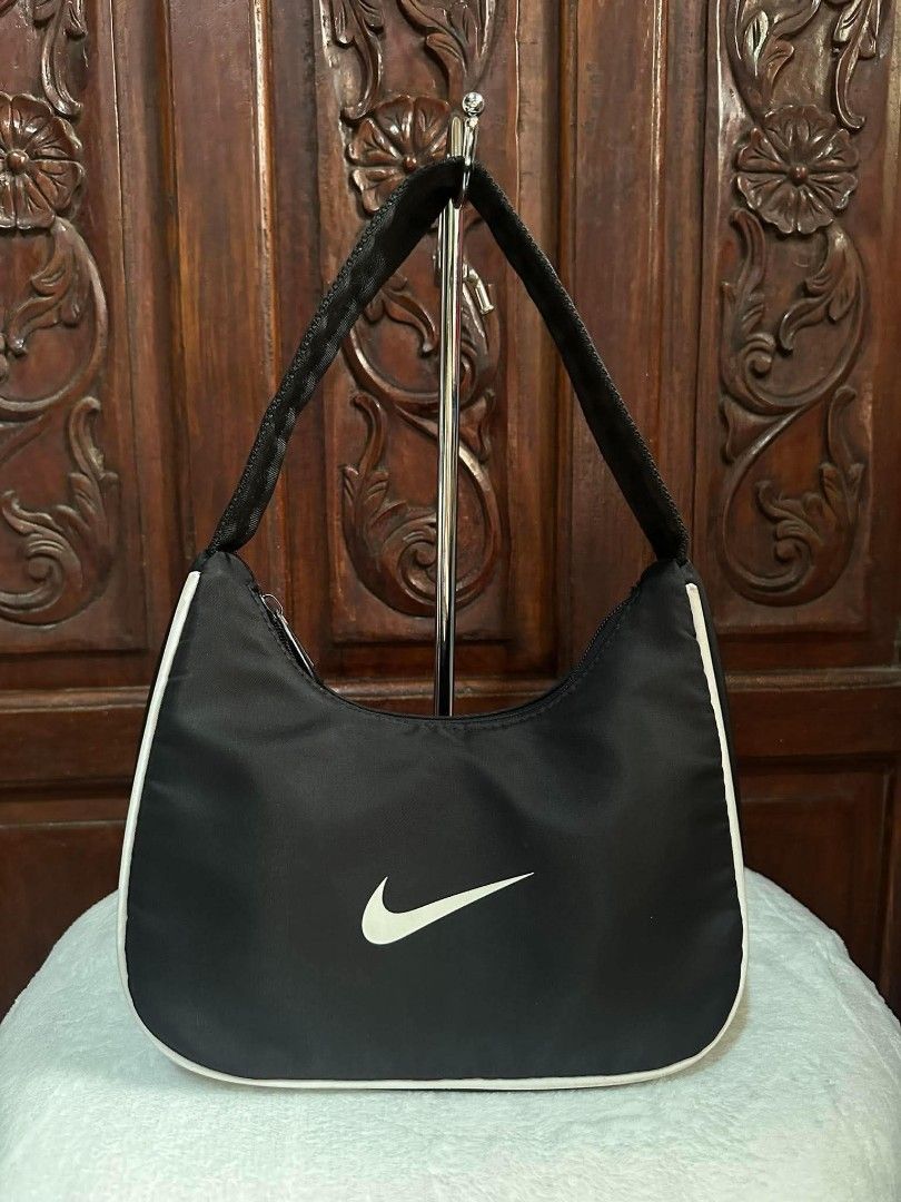 Nike Black White Shoulder Bag (Category: Shoulder Bags) located in Pasacao. Submitted by kishhuschka (Listing ID 1466650017, Image 1). Description: - Authentic black Nike hobo shoulder bag - Features contrast white piping and white swoosh logo - Secure top zip closure with a comfortable woven single strap - Interior includes official Nike tag - Clean, minimal aesthetic perfect for daily wear - Condition: Excellent / Ready to use.