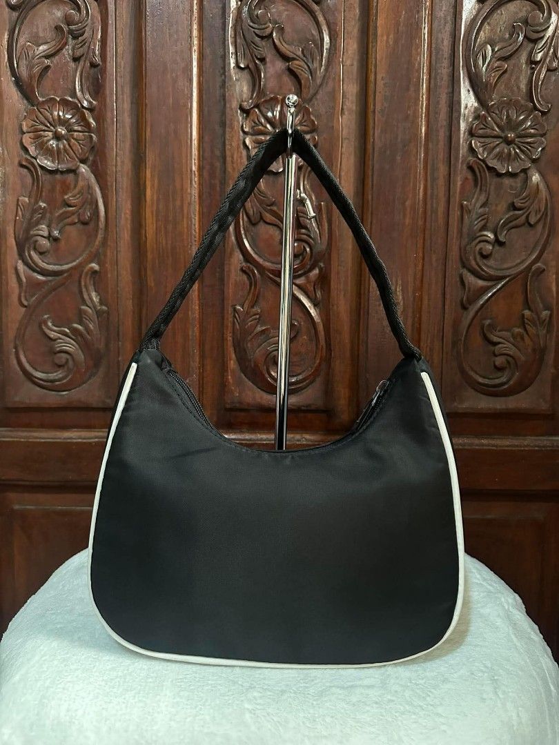 Nike Black White Shoulder Bag (Category: Shoulder Bags) located in Pasacao. Submitted by kishhuschka (Listing ID 1466650017, Image 2). Description: - Authentic black Nike hobo shoulder bag - Features contrast white piping and white swoosh logo - Secure top zip closure with a comfortable woven single strap - Interior includes official Nike tag - Clean, minimal aesthetic perfect for daily wear - Condition: Excellent / Ready to use.