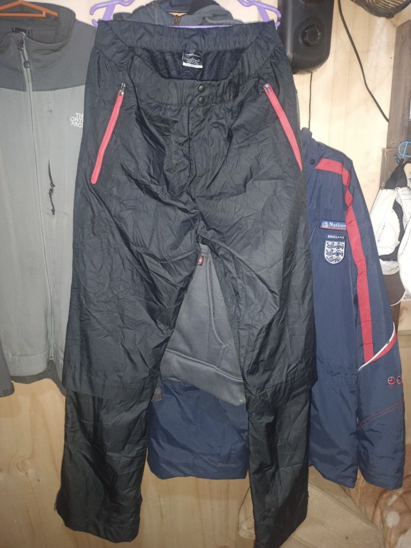 Nike Golf Black Track Pants (Category: Trousers) located in Manila. Submitted by rhoydyyy (Listing ID 1466651033, Image 2). Description: - Brand: Nike Golf - Color: Black with red accents - Size: Large (true to size) - Material: Lightweight, waterproof, packable - Features: Elastic waistband with drawstring, front red zipper pockets, subtle red Nike swoosh on back pocket - Origin: Made in Vietnam (nikebetterworld tag inside).