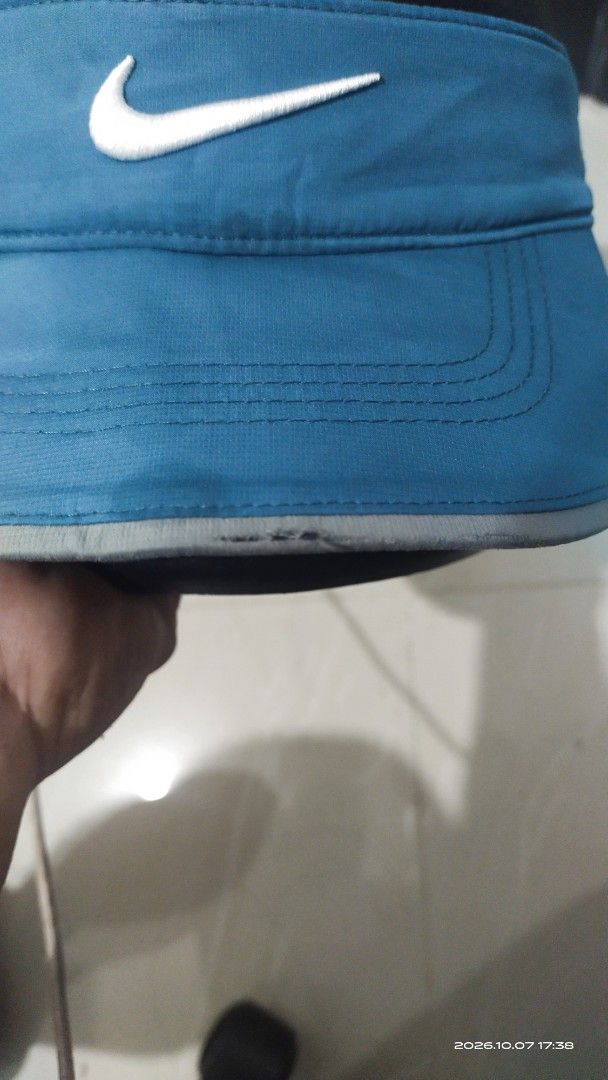 Nike Golf RZN Visor Teal Blue (Category: Caps & Hats) located in Manila. Submitted by rhobin.m08 (Listing ID 1466702742, Image 2). Description: - Brand: Nike Golf - Color: Teal blue with a large embroidered white swoosh on the front - Detail: RZN text printed across the back strap - Closure: Adjustable velcro strap at the rear - Condition: Shows minor wear and fraying along the brim edge as pictured meron gasgas sa brim kita nman sa pic. at bakba