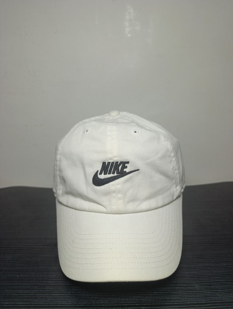 Nike Heritage86 White Cap Hat (Category: Caps & Hats) located in Pasig City. Submitted by firstpick_thrift (Listing ID 1466773037, Image 2). Description: - Authentic Nike Heritage86 collection - Color: White with embroidered black Nike logo - Classic curved brim design - Adjustable metal strap closure for a custom fit - Clean canvas fabric - Intact internal tags showing material and sizing details.
