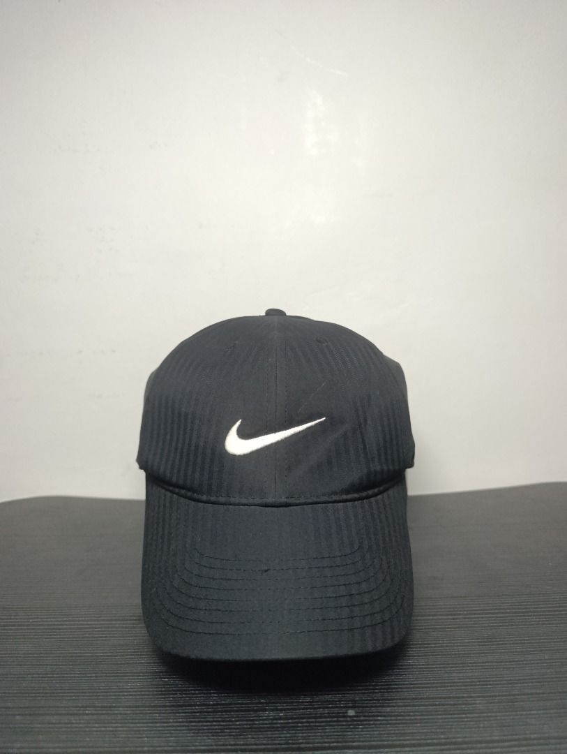 Nike Legacy91 Dri-FIT Black Golf450 Cap (Category: Caps & Hats) located in Pasig City. Submitted by firstpick_thrift (Listing ID 1466772997, Image 1). Description: - Color: Classic Black - Material: Nike Dri-FIT (keeps you cool and dry) - Design: Structured panels with subtle vertical striped texture - Branding: Embroidered white Swoosh on front and back - Closure: Adjustable strap with metal buckle for a custom fit - Condition: Excellent, clean 