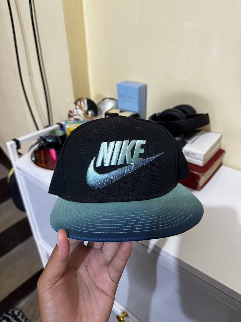 Nike True Snapback Cap Black Teal Gradient (Category: Caps & Hats) located in Baler. Submitted by sidequester (Listing ID 1466569945, Image 1). Description: - Brand: Nike True - Style: Snapback cap - Color: Black with teal gradient brim - Logo: Embroidered teal and silver iridescent Nike logo on front - Closure: Adjustable strap with metal clasp - MOP: Any online bank or e-wallets - MOD: Can do meet up and ship nationwide - Can offer discount or 