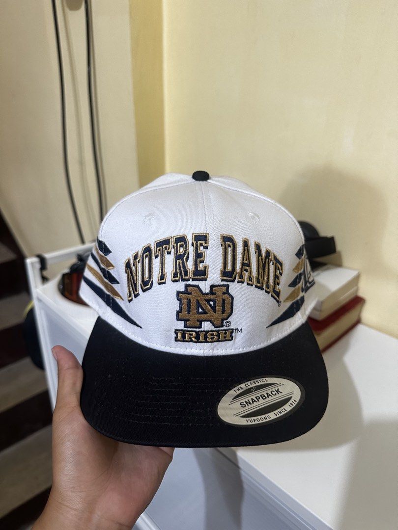 Notre Dame Fighting Irish Snapback Cap Hat (Category: Caps & Hats) located in Baler. Submitted by sidequester (Listing ID 1466584261, Image 1). Description: - Notre Dame Fighting Irish - Color: White crown, black brim, green undervisor - Details: Embroidered front and side graphics, original sticker intact on brim - Closure: Adjustable snapback - MOP: Any online bank or e-wallets - MOD: Can do meet up and ship nationwide - Can offer discount or b