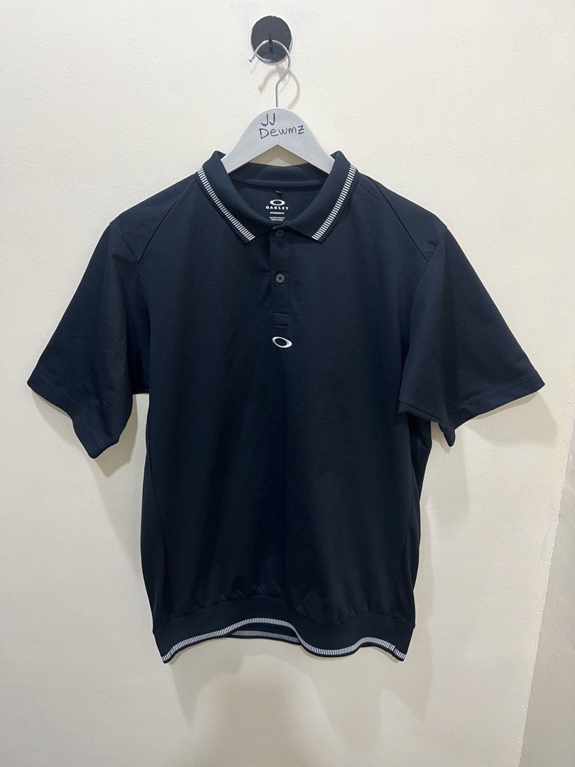 Oakley Black Performance Fit Polo Shirt (Category: Tshirts & Polo Shirts ) located in Ozamiz City. Submitted by jjdewmz (Listing ID 1466687287, Image 1). Description: - Brand: 100% Authentic Oakley - Color: Black - Size: M (US/EU) / L (JPN) - Design: Short sleeves with contrast striped ribbing on collar and hem - Details: Button placket with branded buttons - Back Graphic: Large white Oakley stacked logo with 'ALMOST AN UNFAIR ADVANTAGE.' tagline