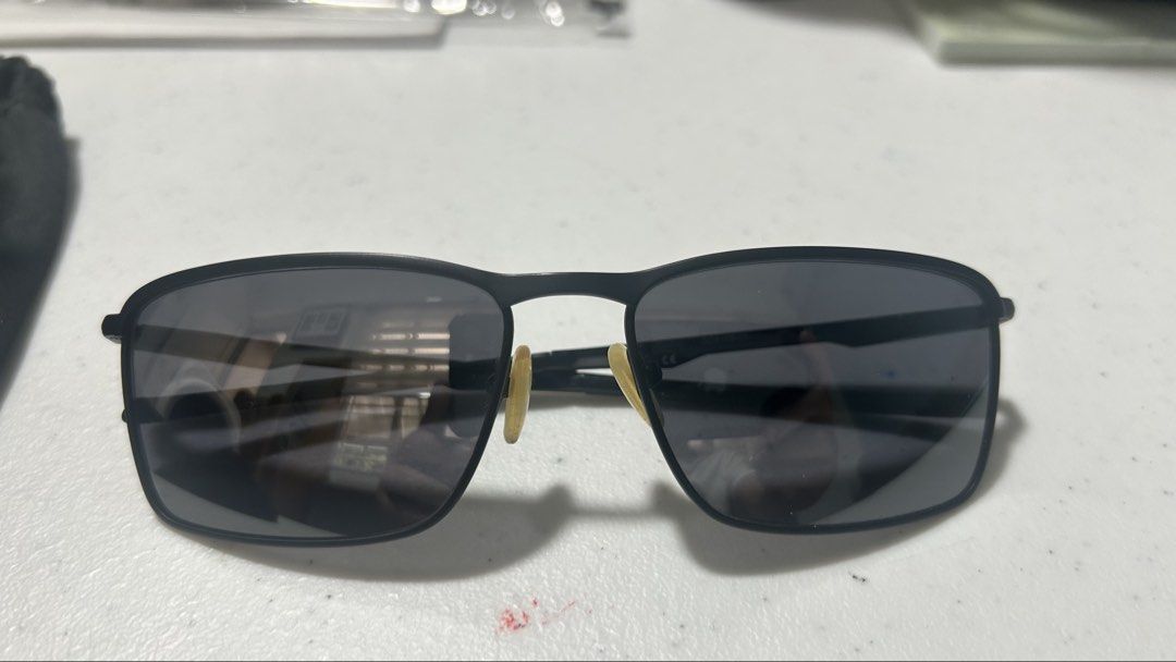 Oakley Conductor 6 Sunglasses Black Frame (Category: Sunglasses & Eyewear) located in Taguig. Submitted by karlonobs (Listing ID 1466580857, Image 2). Description: - Brand: Oakley - Frame: Matte black rectangular metal frame with clear slim arms - Lenses: Dark grey for daily sun protection and driving - Details: Iconic Oakley logo on temples - Condition: Good, but nose pads have yellowed from age - Perfect daily driver shades, grab them before so