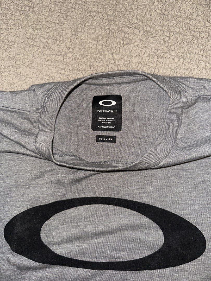 Oakley Performance Grey Hydrolix T-Shirt Size M (Category: Tshirts & Polo Shirts ) located in Quezon City. Submitted by mancave_stuff (Listing ID 1466563771, Image 2). Description: -Grey Oakley t-shirt with large black ellipse logo on the chest. -Short sleeves, crew neck. -Hydrolix performance fabric keeps things dry and comfortable. -Size US/EU M (JPN L) W19.5” x L27” -Made in Honduras. -Excellent condition..