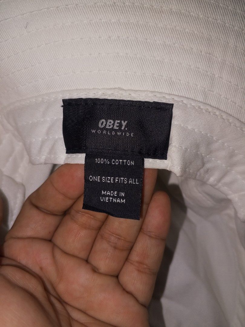 Obey Worldwide White Bucket Hat (Category: Caps & Hats) located in Magalang. Submitted by zeiansoria64090 (Listing ID 1466594679, Image 3). Description: - 100% breathable cotton material - Classic white color with black embroidered Obey Worldwide logo - One size fits all design - Clear brand and material tags inside - Ideal casual streetwear accessory for sunny days.