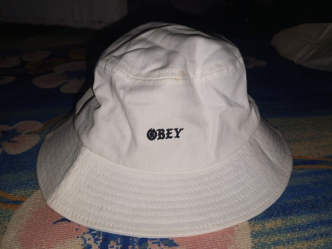 Obey Worldwide White Bucket Hat (Category: Caps & Hats) located in Magalang. Submitted by zeiansoria64090 (Listing ID 1466594679, Image 1). Description: - 100% breathable cotton material - Classic white color with black embroidered Obey Worldwide logo - One size fits all design - Clear brand and material tags inside - Ideal casual streetwear accessory for sunny days.