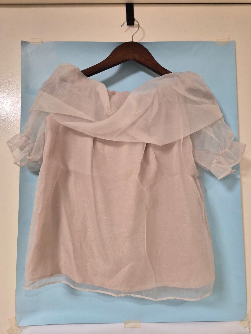 Off shoulder sheer ruffle blouse in cream beige (Category: Blouses) located in Manila. Submitted by prelovedbyc.hannah (Listing ID 1466713602, Image 2). Description: - Color: Cream beige - Style: Off-shoulder sheer blouse with draped ruffle overlay - Sleeves: Short sleeves with ruffled cuffs - Construction: Double-layered, lightweight, and airy fabric - Styling: Great for pairing with skirts or high-waisted jeans - Condition: Excellent / like new