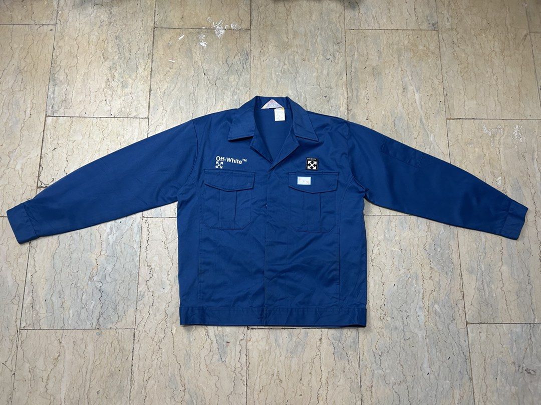 Off-White Blue Workwear Jacket Size L (Category: Coats, Jackets and Outerwear) located in Mandaluyong City. Submitted by 0lg2026 (Listing ID 1466751817, Image 2). Description: - Brand: Off-White - Item: Bold Blue Workwear Jacket - Material: Heavyweight cotton for structure and warmth - Design: Classic collar, button-up front, dual chest pockets - Details: White branding on right chest, small arrow patch on left, large distressed arrow graphic on 