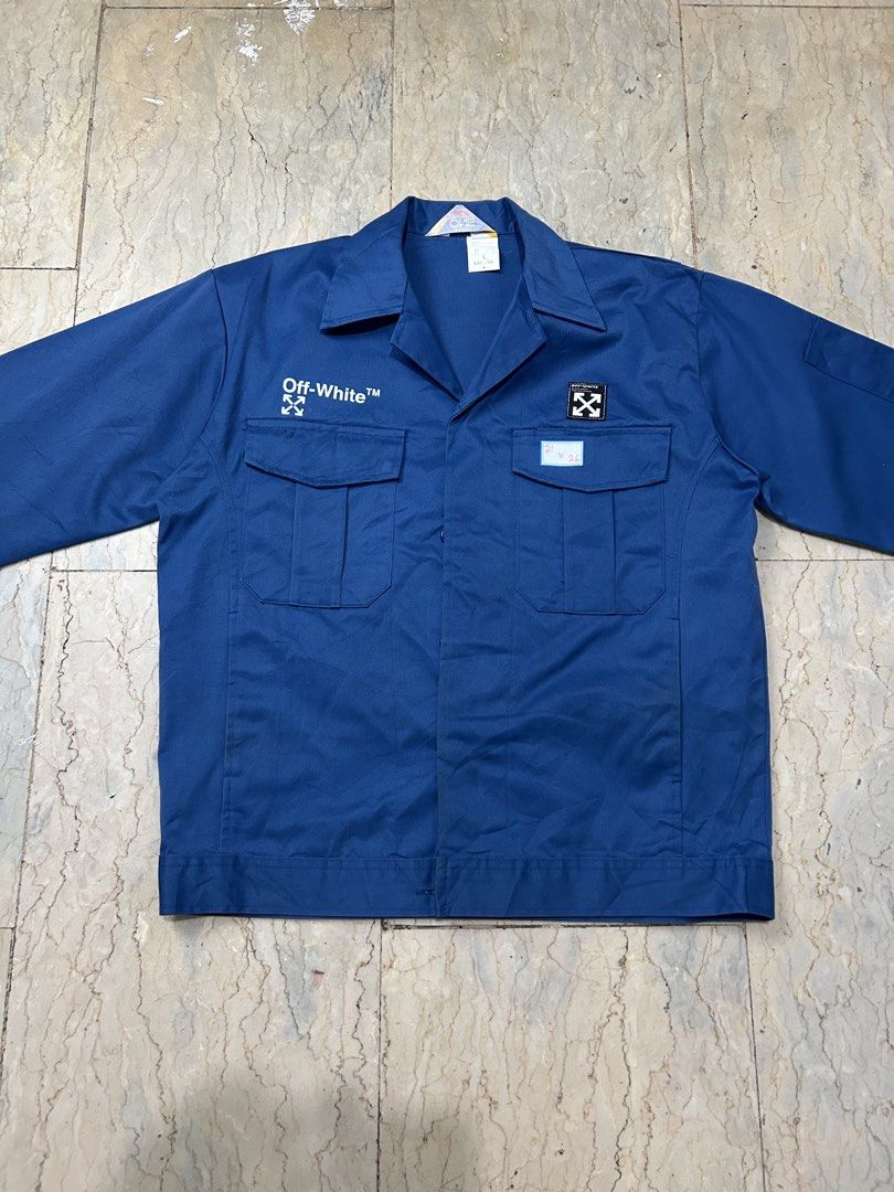 Off-White Blue Workwear Jacket Size L (Category: Coats, Jackets and Outerwear) located in Mandaluyong City. Submitted by 0lg2026 (Listing ID 1466751817, Image 3). Description: - Brand: Off-White - Item: Bold Blue Workwear Jacket - Material: Heavyweight cotton for structure and warmth - Design: Classic collar, button-up front, dual chest pockets - Details: White branding on right chest, small arrow patch on left, large distressed arrow graphic on 