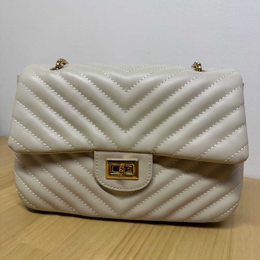 Off-white Chevron Quilted Shoulder Bag with Gold Chain (Category: Luxury Bags & Wallets) located in Mandaluyong City. Submitted by jldlnd (Listing ID 1466677731, Image 2). Description: - Used once only for a wedding - Color: Off-white / Cream - Material: Faux leather with all-over chevron quilting - Hardware: Gold-tone box chain strap and twist-lock clasp - Design: Structured rectangular shape with gusseted sides - Condition: Clean interior and f